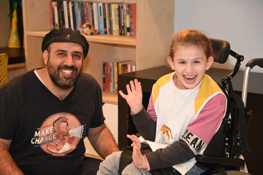 A happy child using an Apri special needs clothing protector designed for dignity and style, pictured in a friendly, supportive environment.